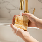 Hands lathering Mabrielle Soap Co. Papaya Goat Milk Soap bar under running water